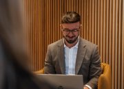 en revisor på ett kontor med laptop i knät